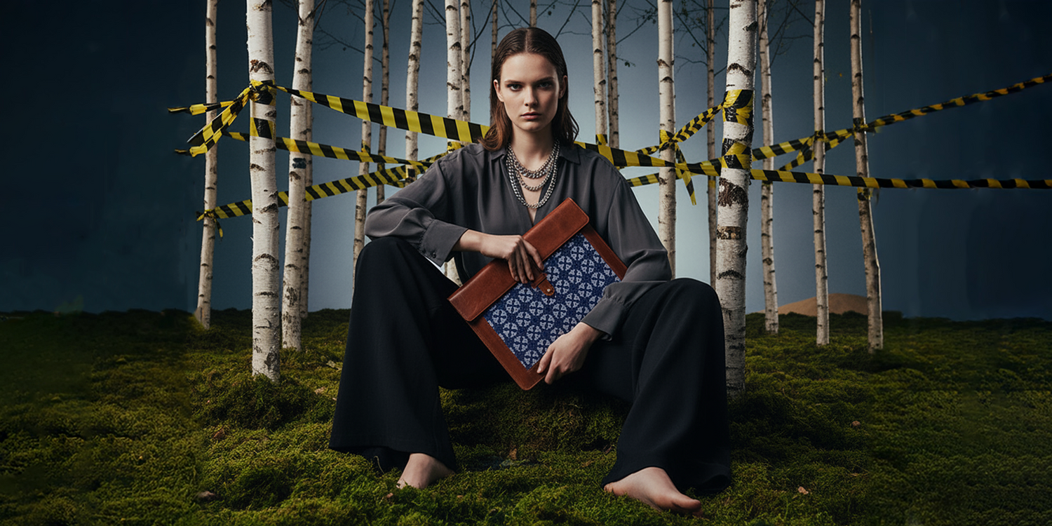 Person holding a book in a forest with caution tape, dark and moody atmosphere