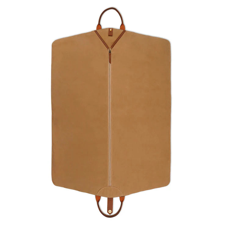 Tan garment bag with leather straps on a white background