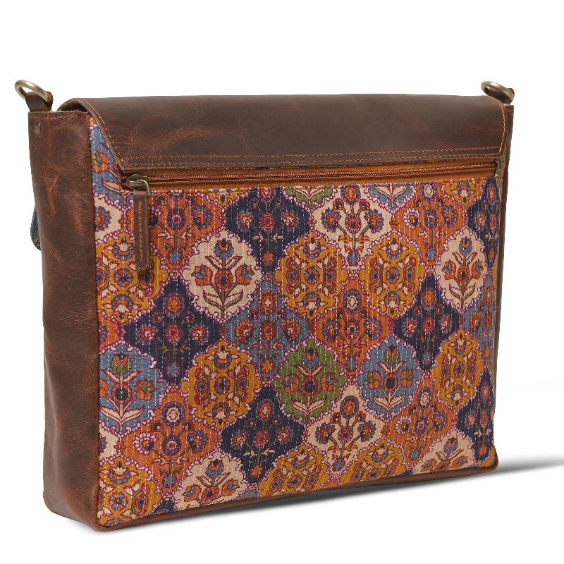 Brown leather bag with a colorful patterned flap on a white background