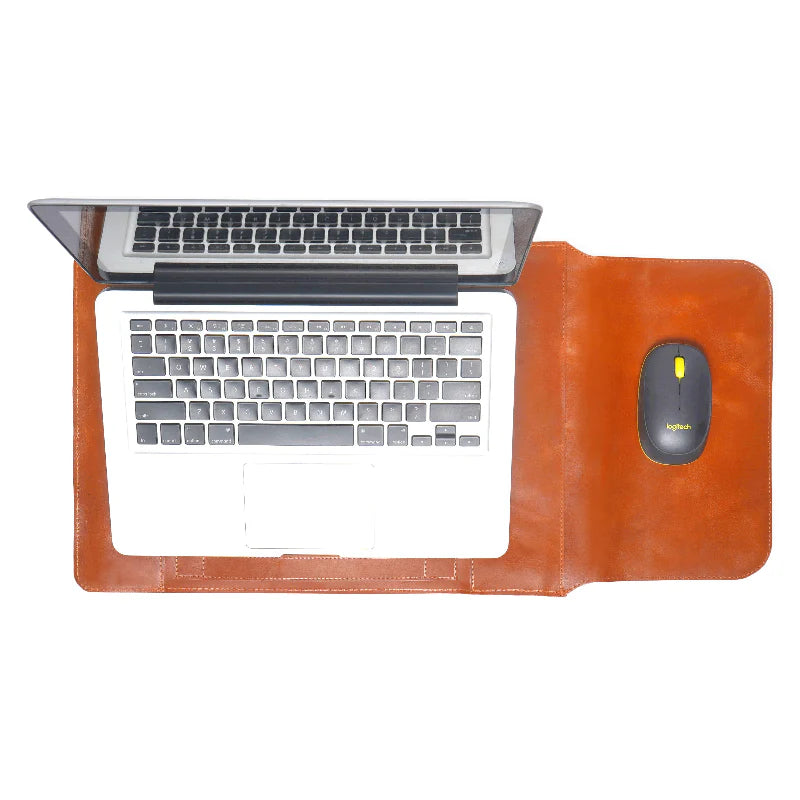 Laptop on a brown leather desk pad/sleeve with keyboard and mouse