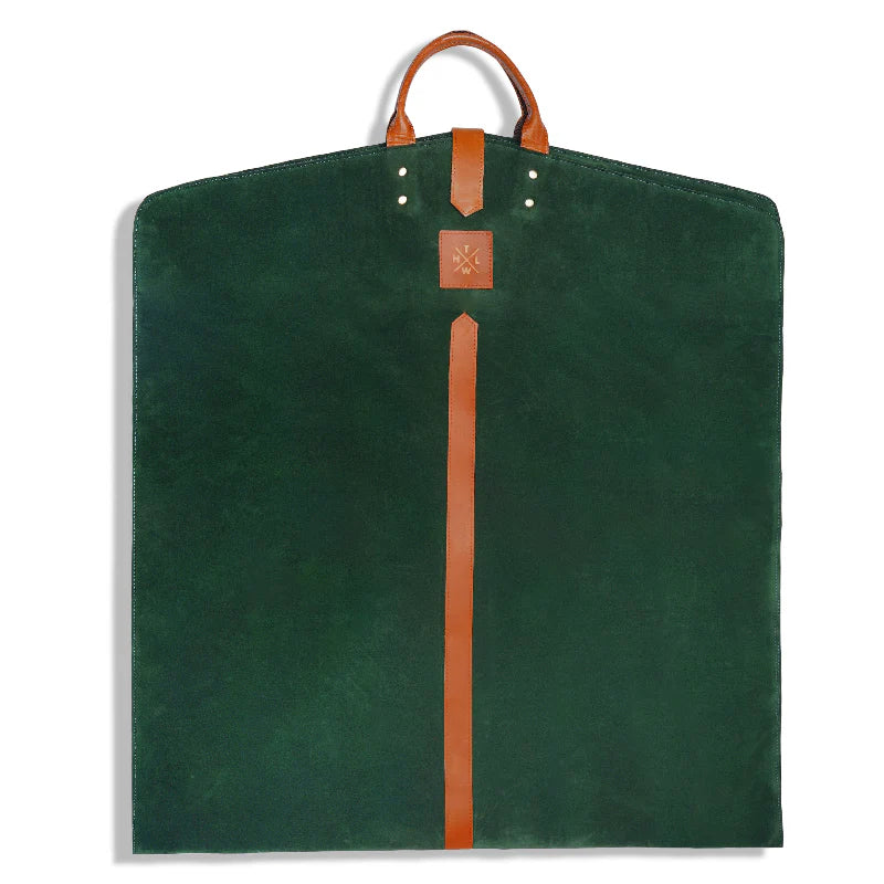 Green garment bag with brown leather strap and handle on a white background