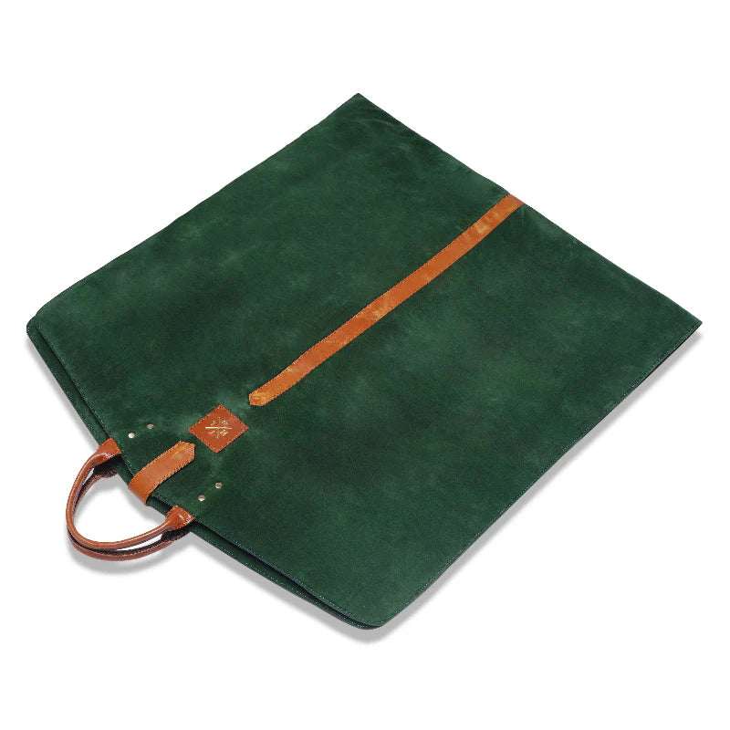 Green suede bag with brown leather accents on a white background