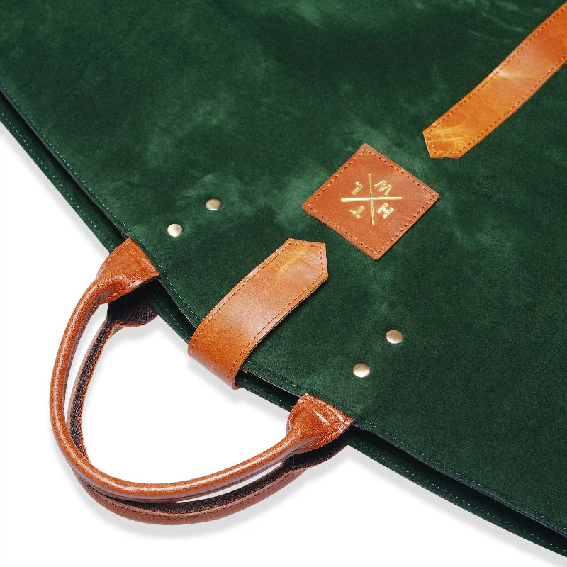 Green bag with brown leather handles and a visible brand logo on a white background