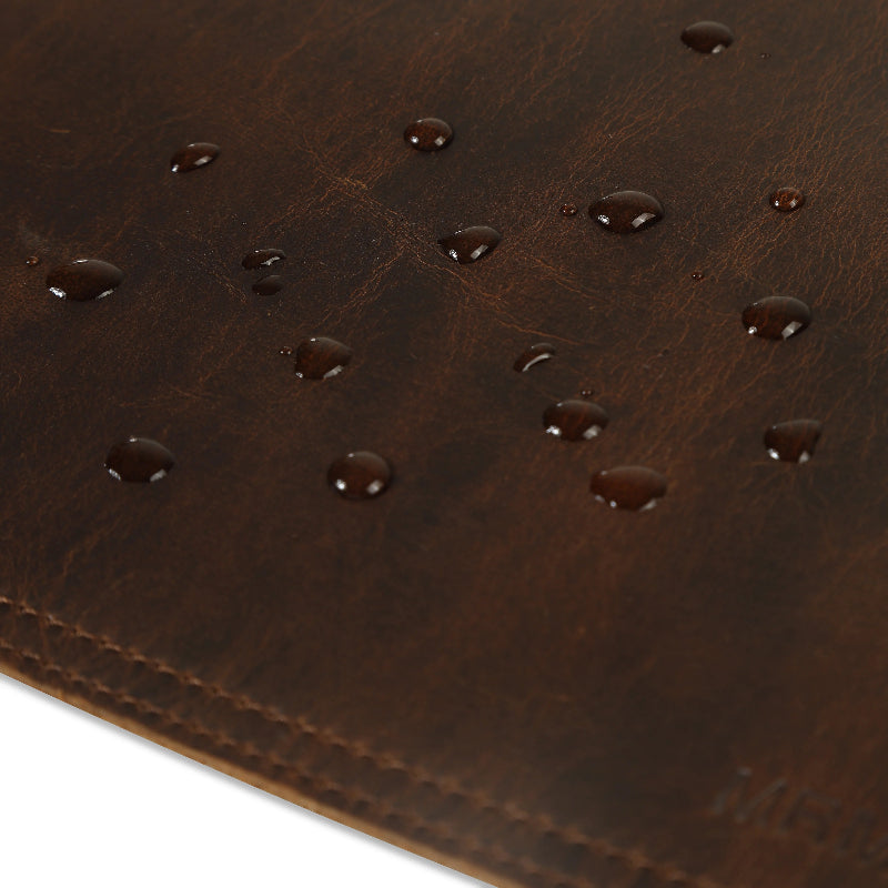 Close-up of a brown leather desk matwith water droplets.