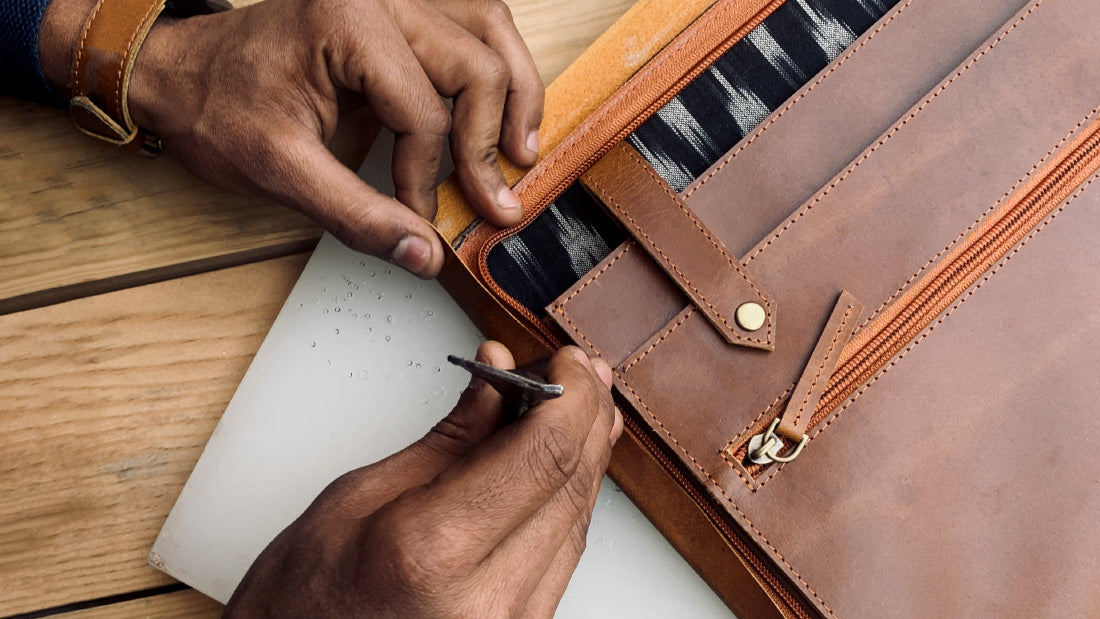 A person holds a leather case containing a pen and a file folder, showcasing a professional writing setup.
