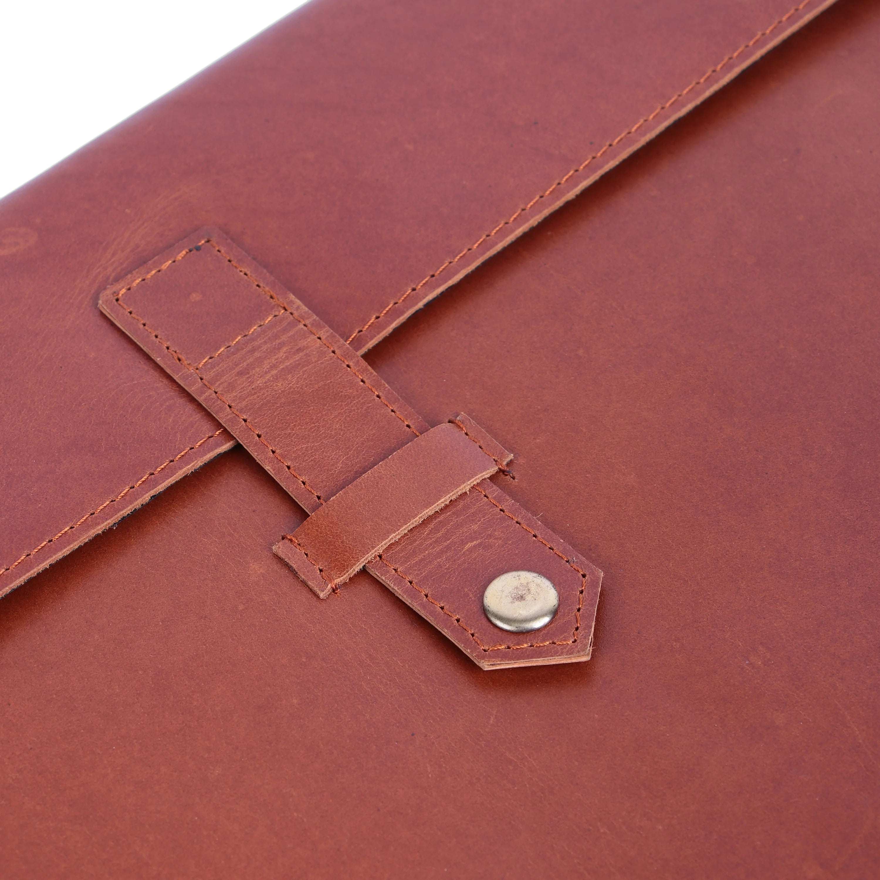 Close-up of a brown leather sleeve with a strap and button closure.