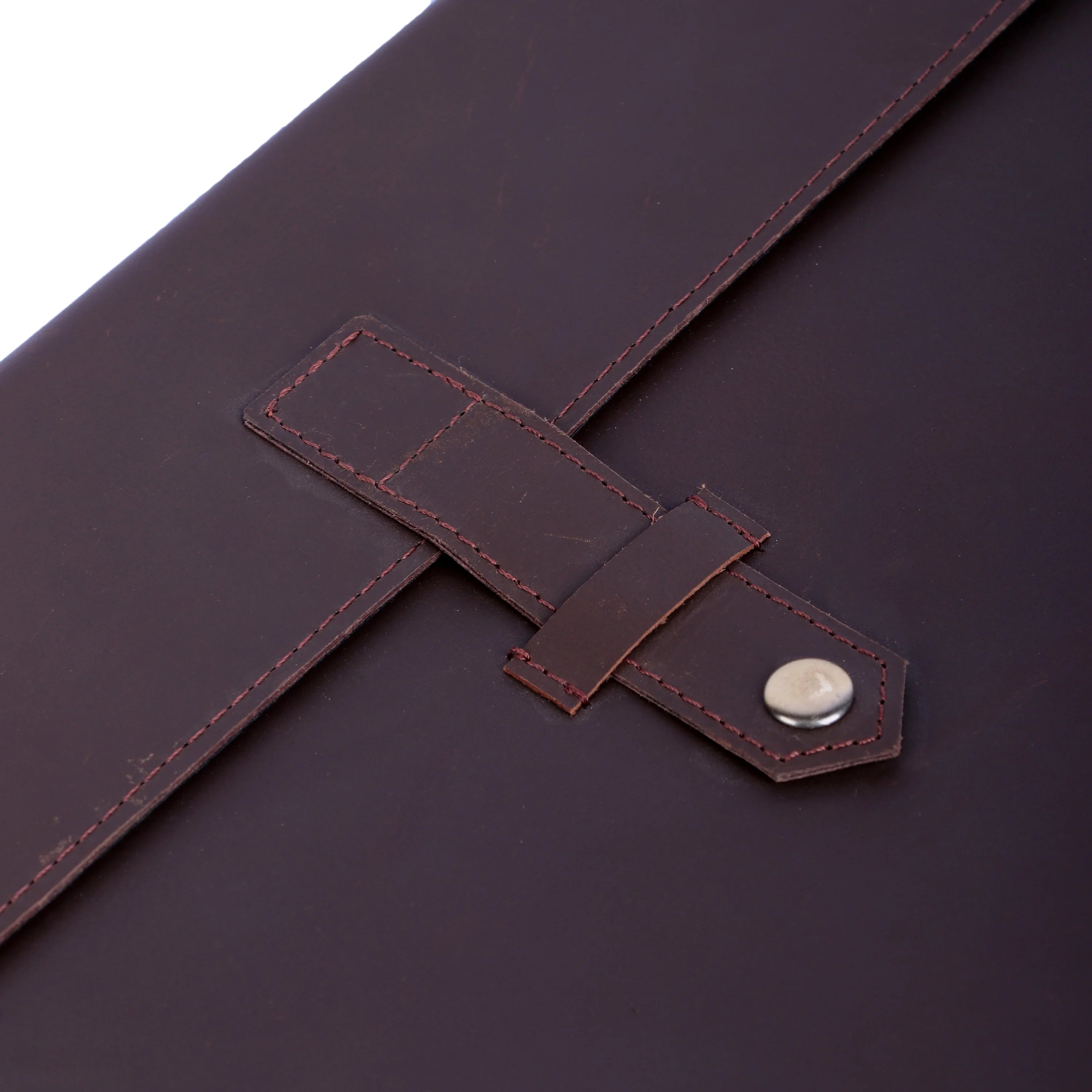 Close-up of a brown leather strap with stitching detail on a dark background