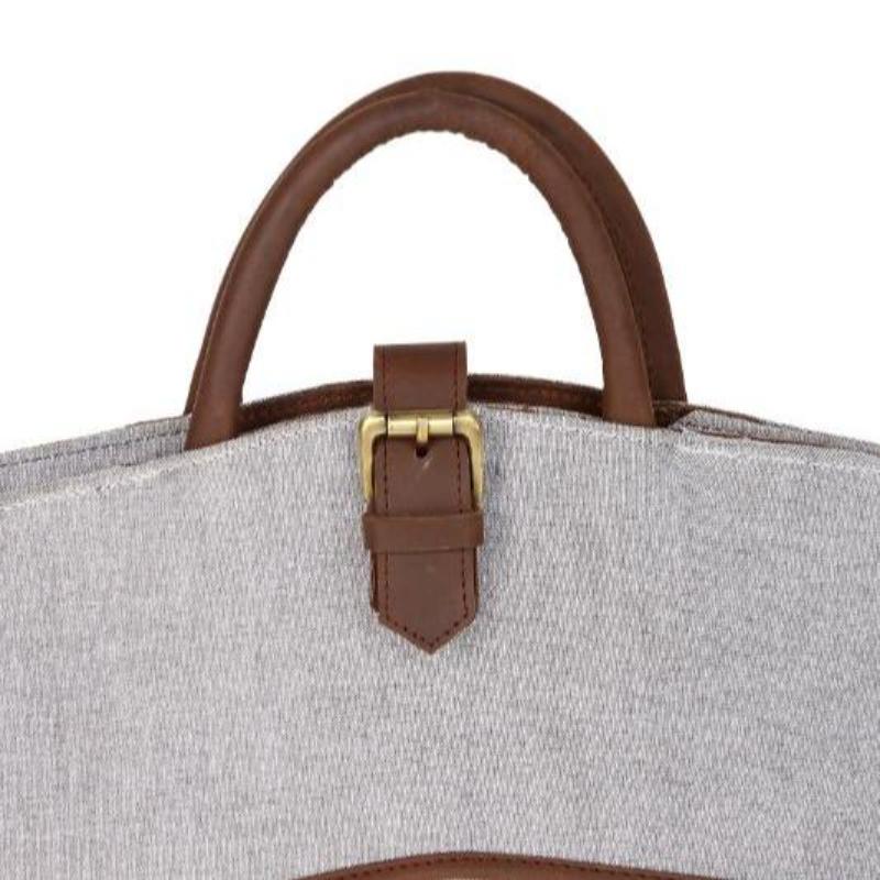 Close-up of a gray bag with brown leather handle and strap on a white background