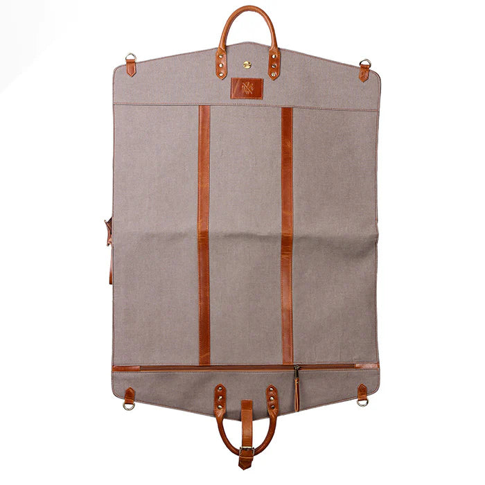 Gray garment bag with brown leather straps and handles on a white background