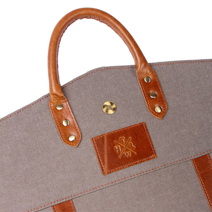 Gray bag with brown leather handles and accents on a white background