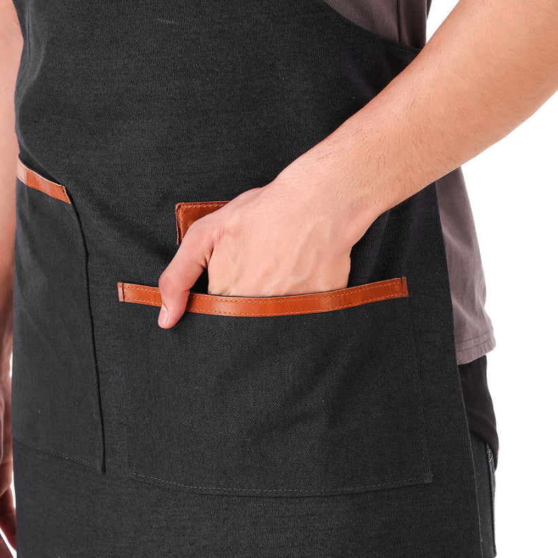 Person wearing a black apron with brown leather pockets on a white background