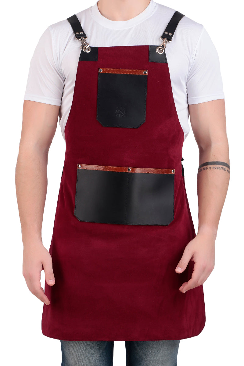 Red apron with black leather pockets worn by a person on a white background