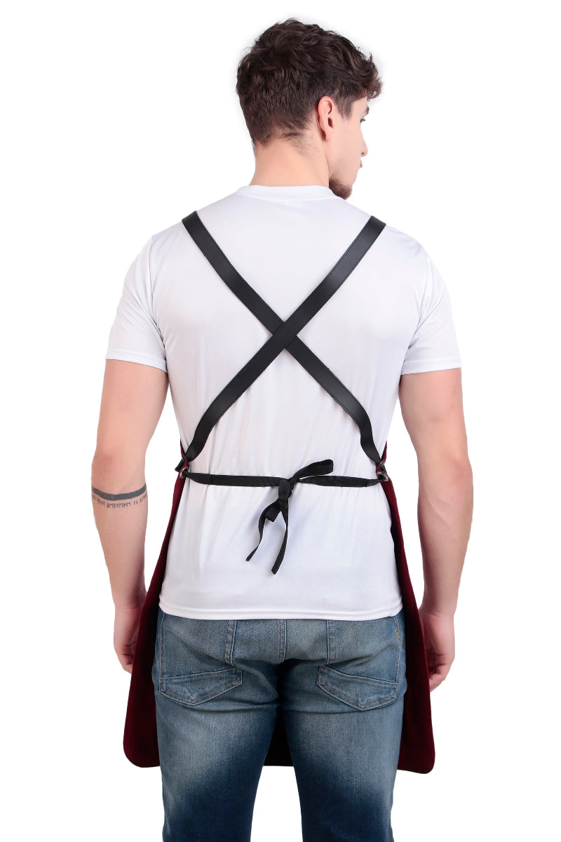Person wearing a white shirt and dark apron with cross straps on a white background