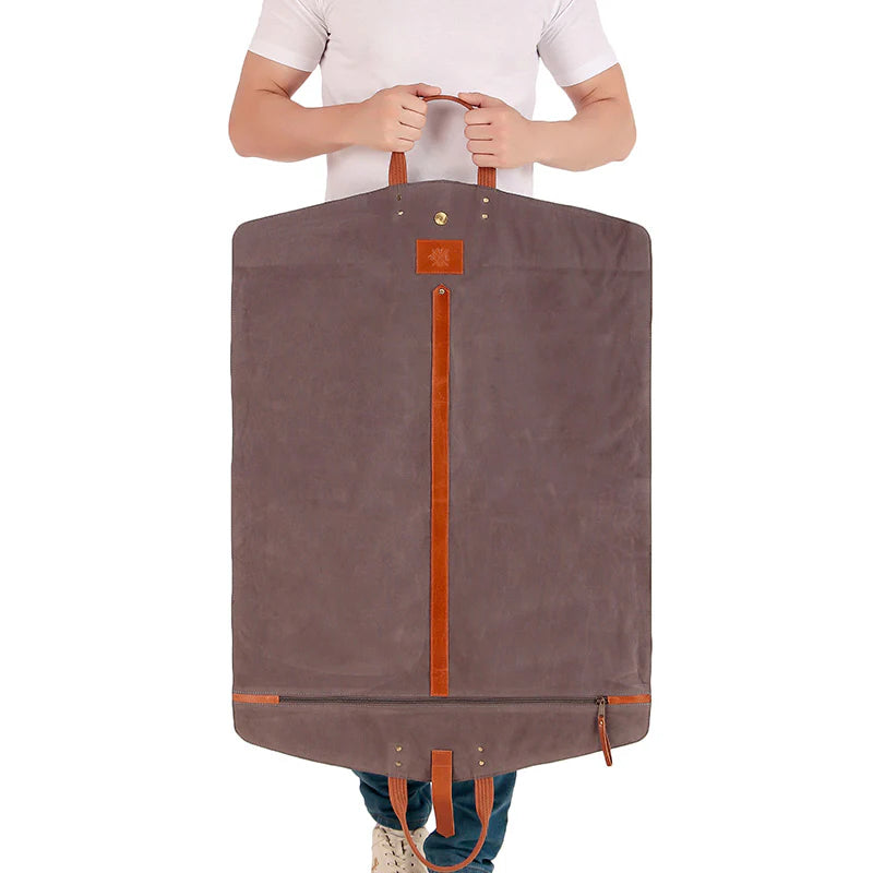 Person holding a large brown garment bag with orange accents on a white background