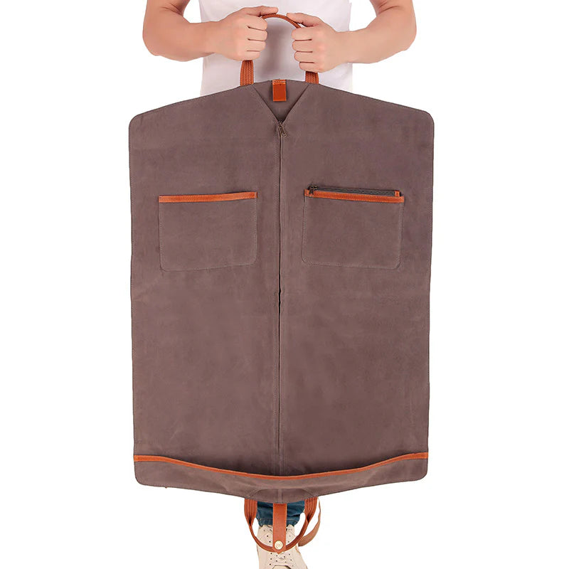 Brown garment bag with orange accents held by a person on a white background