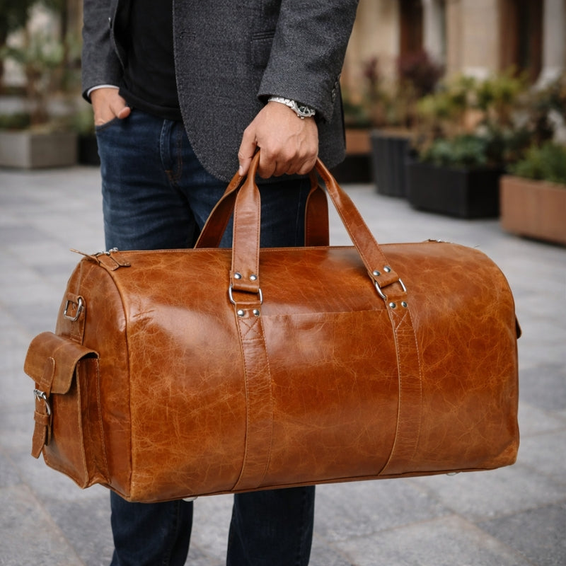 Person holding a brown leather duffel bag outdoors.