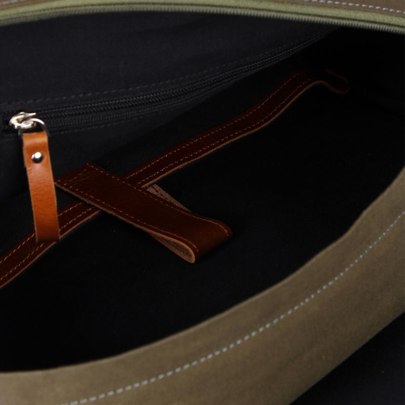 Close-up of a brown leather handle on a bag with visible stitching details.