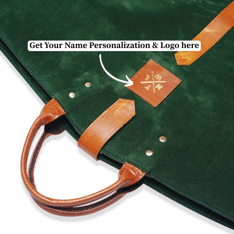 Green garment bag with brown handles and a leather patch on a white background