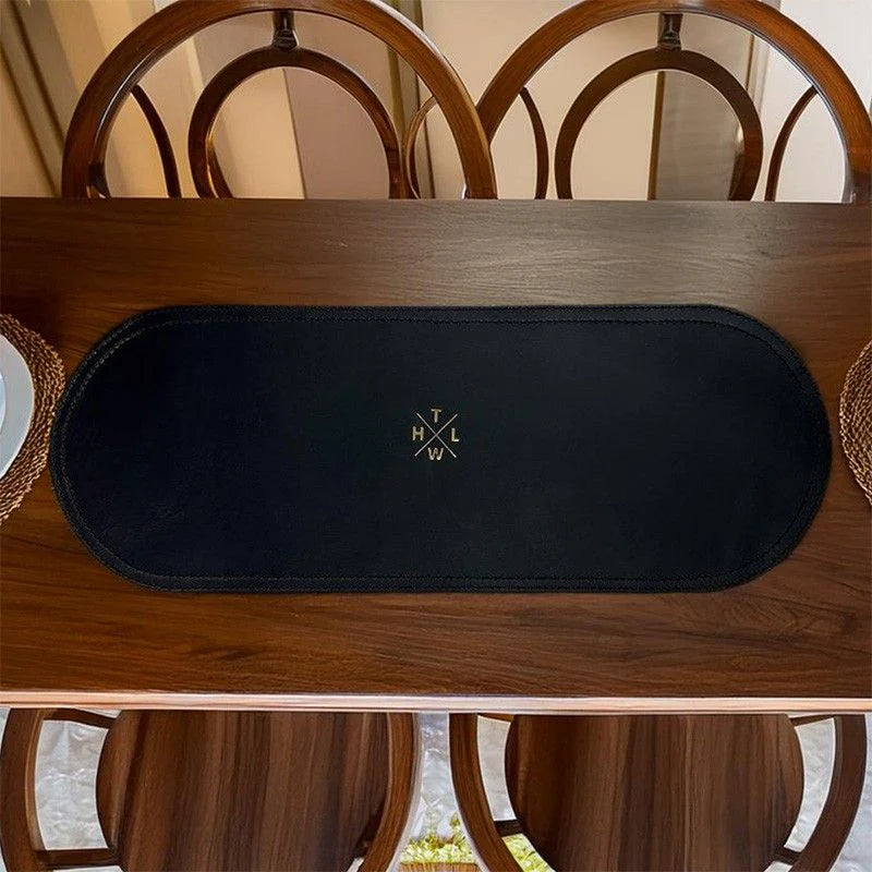 Black placemat with logo on a wooden table