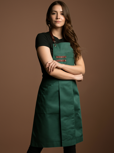 Woman wearing a green apron with brown straps on a brown background