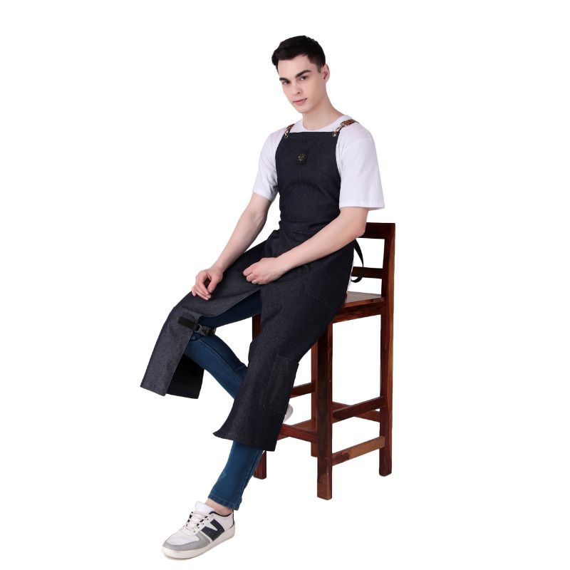 Person wearing a black apron sitting on a wooden chair against a white background