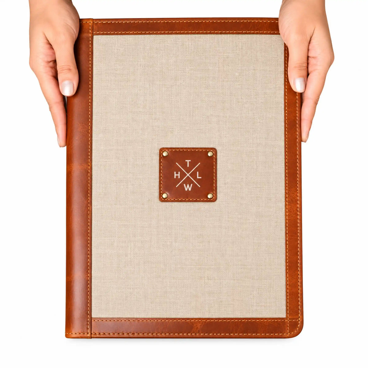 Brown leather and canvas folders displayed together showing contrasting fabric panels and leather finishes