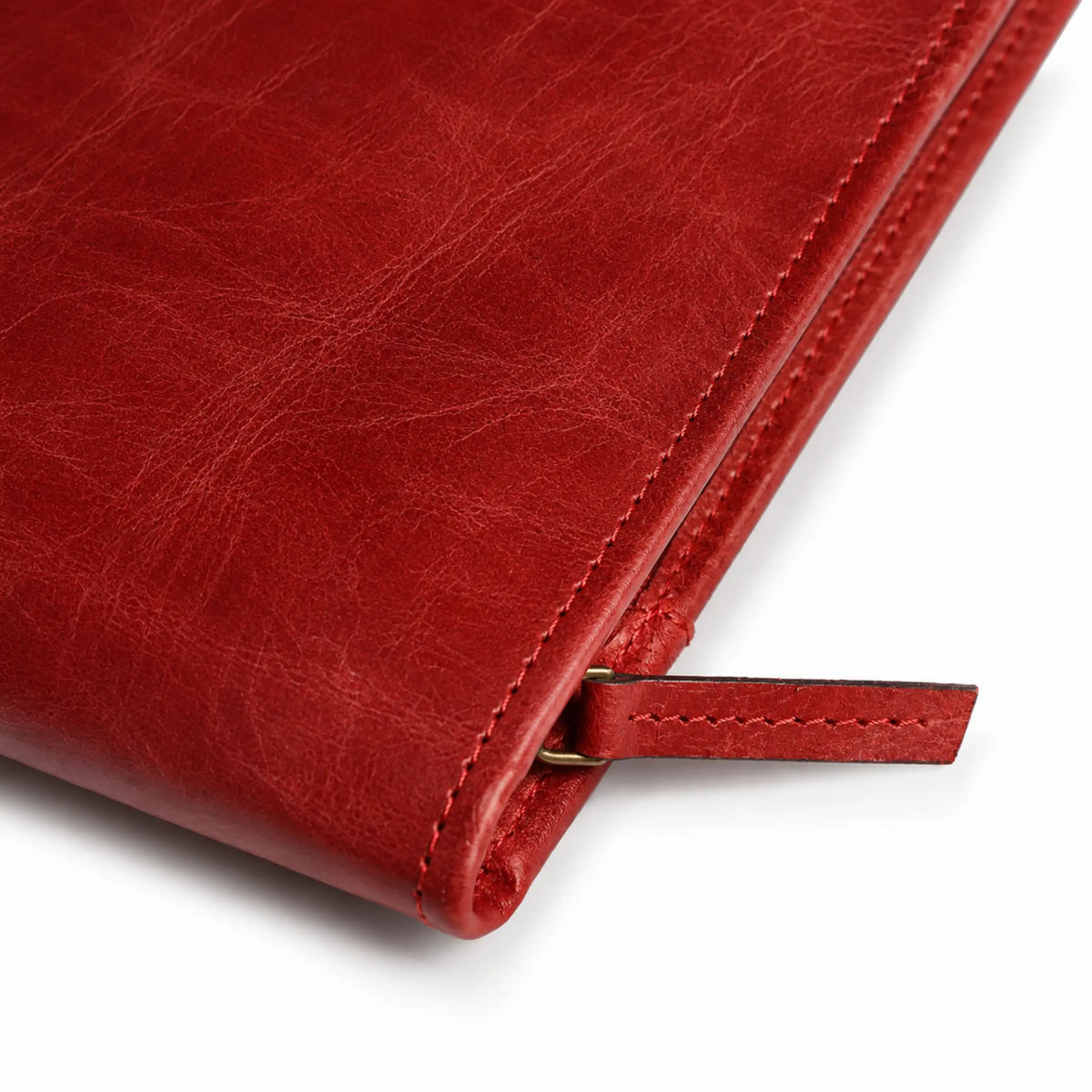 Close-up of burgundy leather portfolio showing its stitched edge, leather texture, and zipper pull