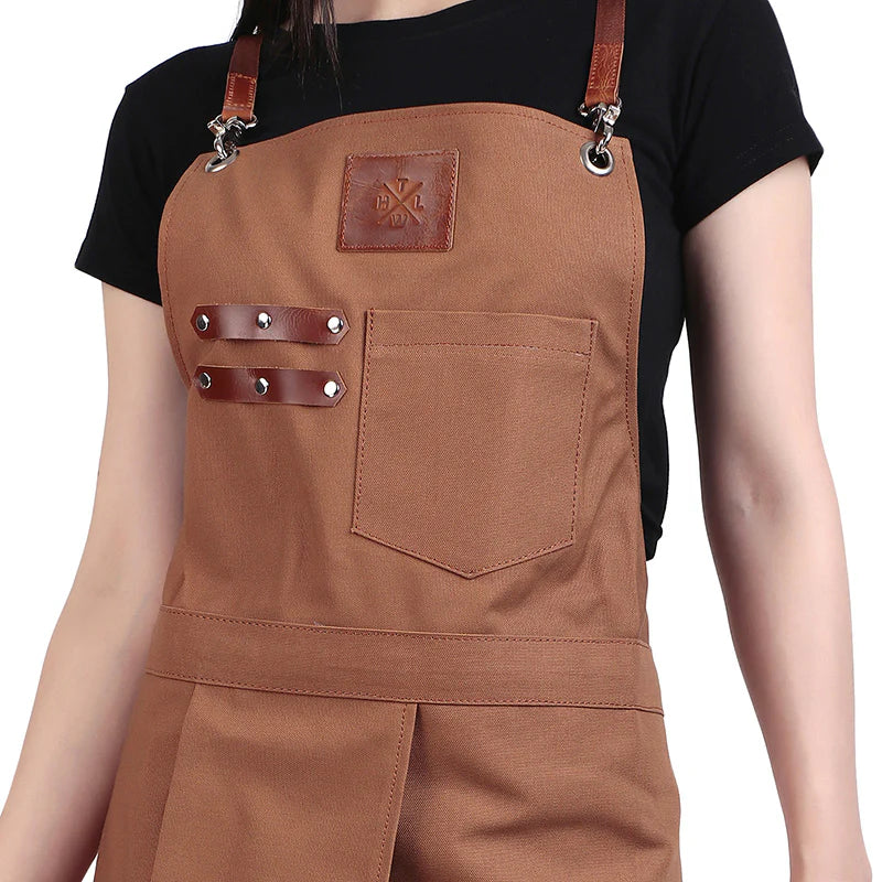 Brown apron with leather straps and pocket on a plain background