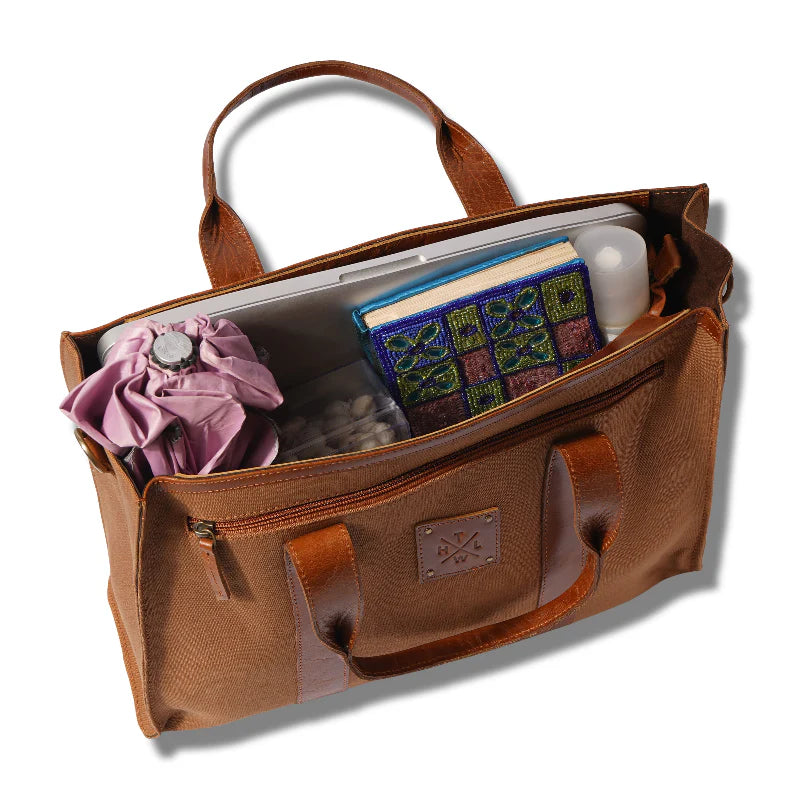 Brown leather bag with various items on a white background