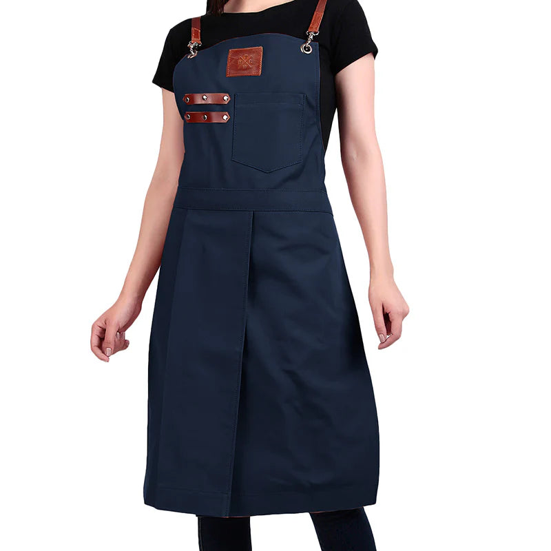 Navy apron with brown leather straps and accents on a white background