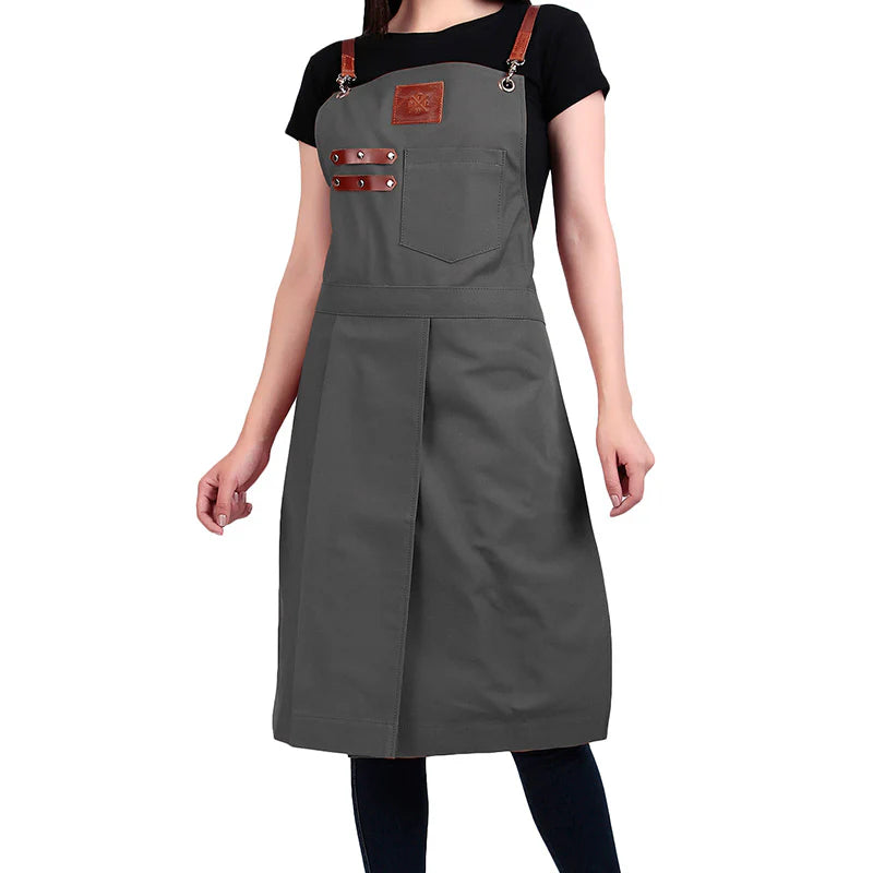 Person wearing a gray apron with brown leather straps on a white background