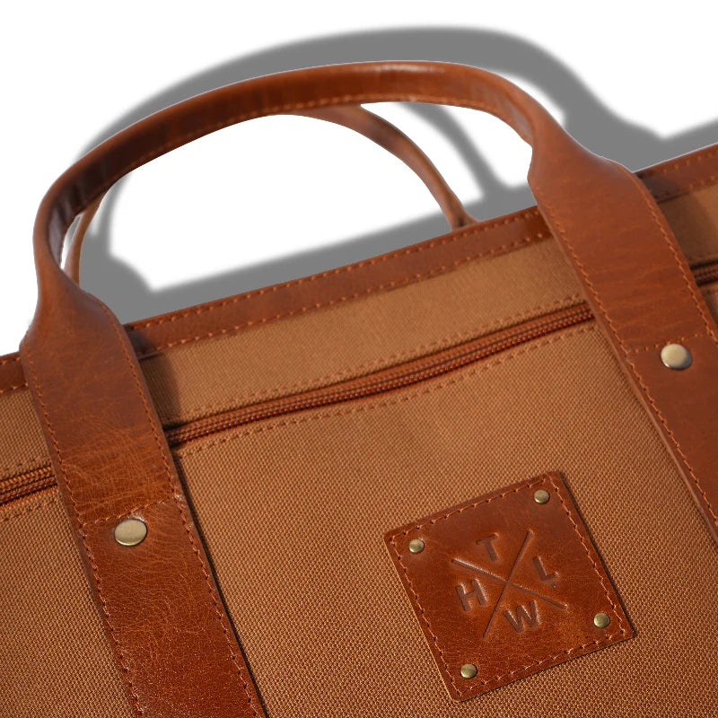 Brown leather bag with handle and visible brand logo on a white background