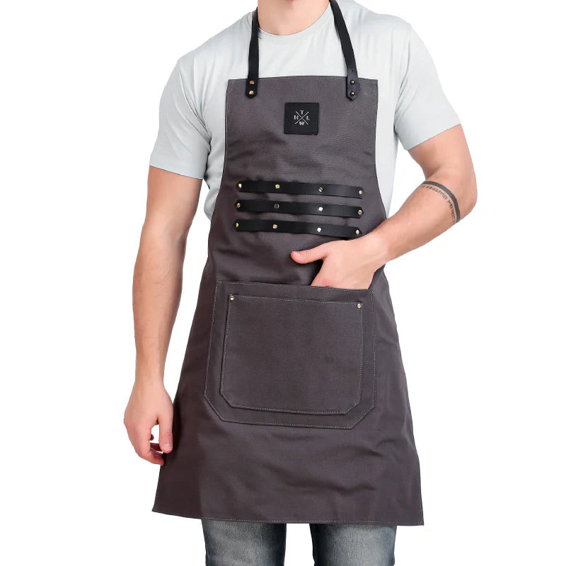Person wearing a gray apron with black straps on a white background