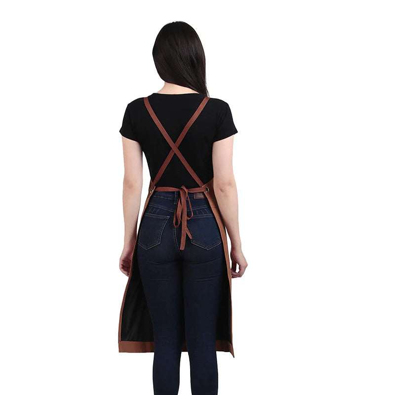 Person wearing a black apron with brown straps on a white background
