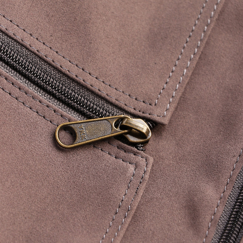 Close-up of a brown leather jacket with a zipper and metal pull.
