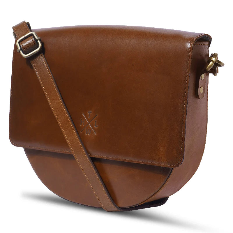 Brown leather bag with a strap on a white background