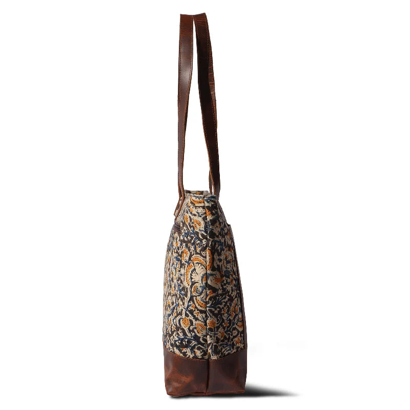 Tote bag with floral pattern and brown leather accents on a white background