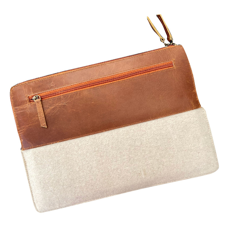 Clutch bag with brown leather top half and beige bottom half on a white background
