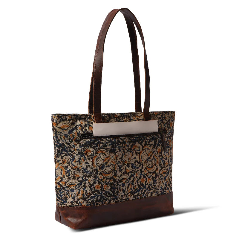 Tote bag with floral pattern and brown leather accents on a white background