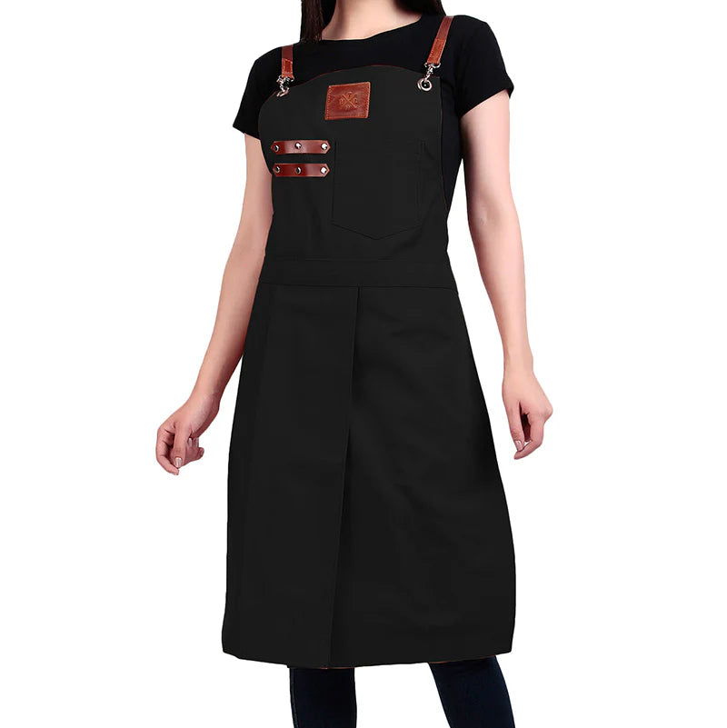 Black apron with brown leather straps worn by a person on a white background