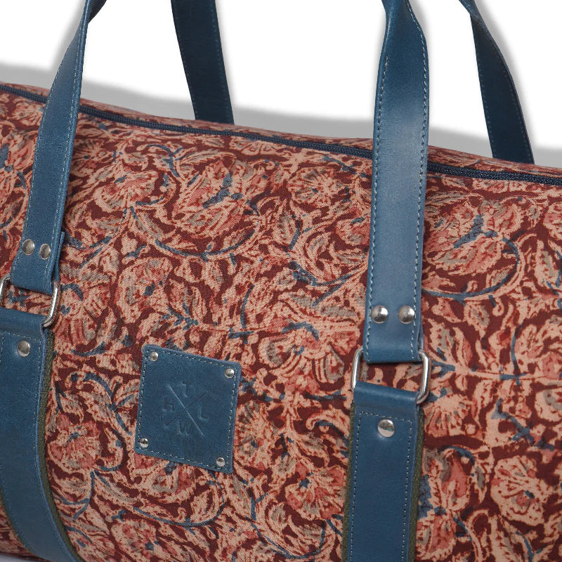 Patterned bag with blue straps and a visible brand logo on a white background