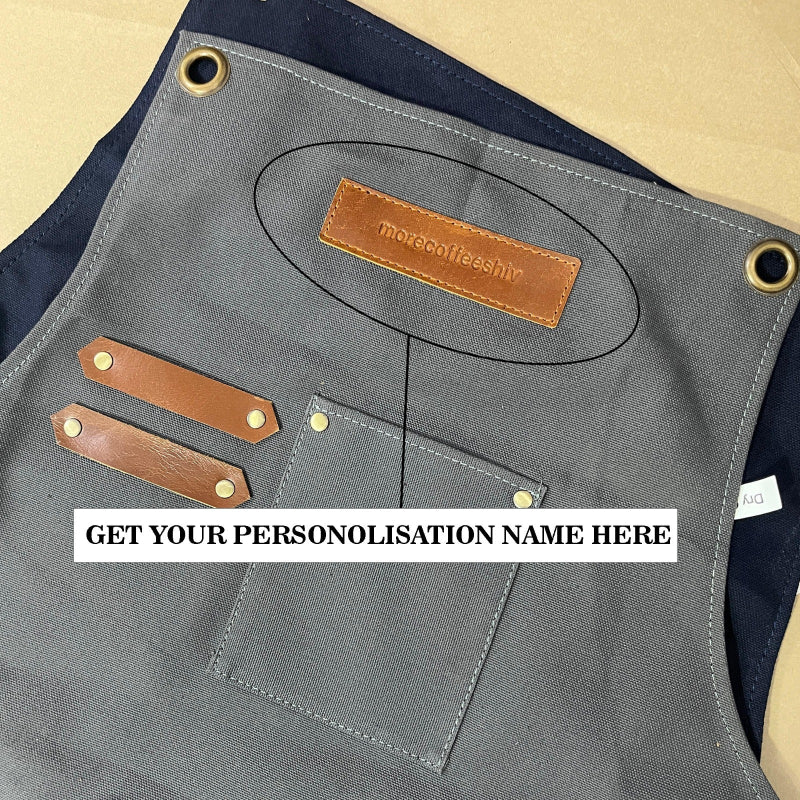 Gray apron with brown leather patches and a visible brand logo, with text overlay for personalization.