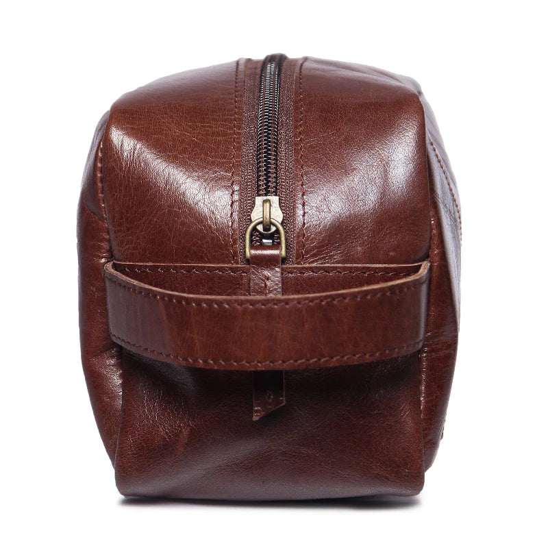 Brown leather toiletry bag with a zipper on a white background