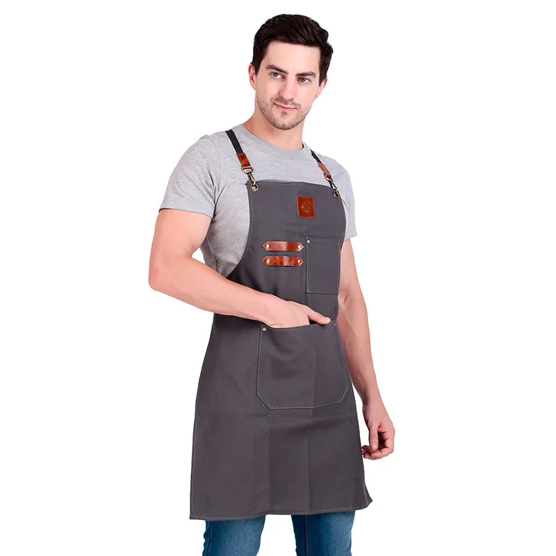 Man wearing a gray apron with brown straps on a white background