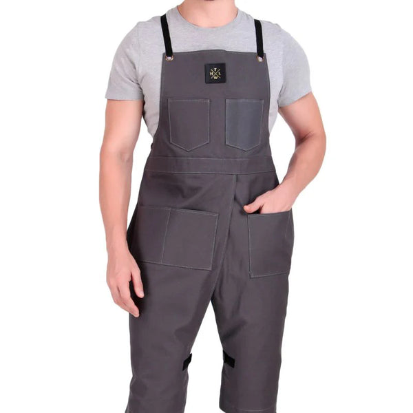 Person wearing a gray bib overalls on a white background