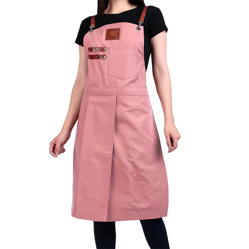 Person wearing a pink apron with brown straps on a white background