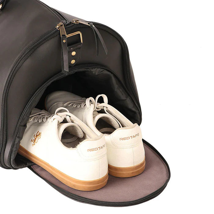 White sneakers with brown soles inside an open black suitcase on a white background