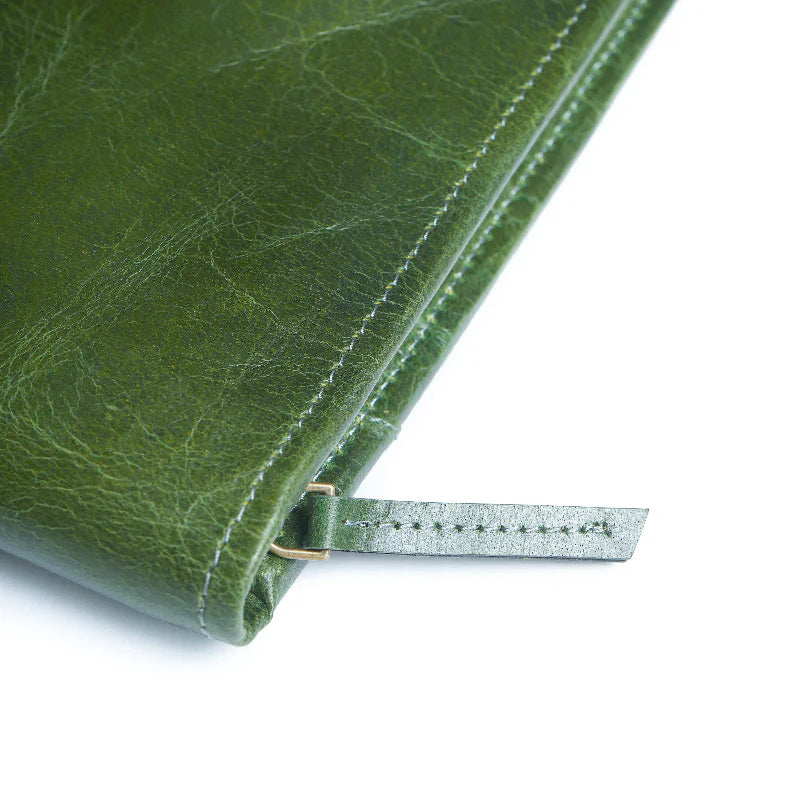 Close-up of a green leather product with a strap on a white background