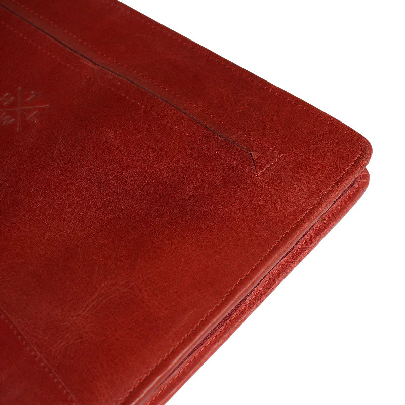 Close-up of a red leather wallet with visible stitching on a white background