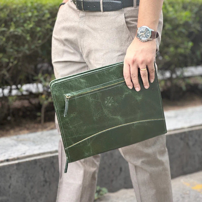 Person holding a green clutch bag outdoors